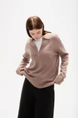 Sweater de punto color azul, con cuello polo y escote en V, de manga larga y diseño holgado.