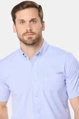 Camisa sport de manga corta a rayas celestes y blancas, con cuello abotonado, cierre frontal con botones y bolsillo ojal en el pecho.
