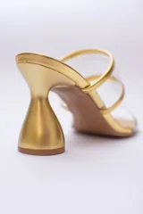 Sandalias plateadas con taco de forma geométrica y tiras transparentes.