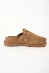 Zueco marrón de gamuza con tachas doradas.