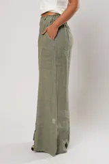 Pantalón verde oliva de lino, corte palazzo, con cintura elástica y aberturas laterales con botones.