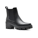 Bota corta de cuero sintético color hueso, con elásticos laterales, caña baja, punta redondeada y suela track con taco cuadrado.