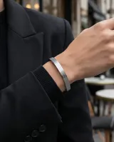 Esclava rígida de acero inoxidable con diseño grabado de guarda griega en toda su superficie.
