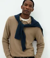 Suéter masculino de punto texturizado en color beige, con cuello polo, manga larga y terminaciones acanaladas en puños y ruedo.