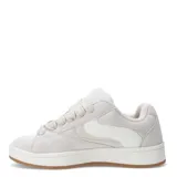 Championes de estilo urbano con diseño bicolor en negro y blanco, confeccionados en material tipo gamuza con cordones anchos blancos y suela de goma color caramelo.