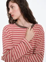 Remera de dormir de corte oversize con estampado de rayas horizontales, confeccionada en algodón con elastano. Presenta cuello redondo en rib de color rojo contrastante y mangas largas.