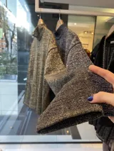 Polera de tejido de algodón con lurex plateado, de cuello alto y corte holgado.