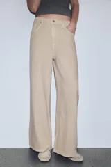 Jeans de tiro alto, color beige claro, con pierna ancha y cinco bolsillos.
