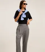 Pantalón de vestir gris con finas rayas verticales, de corte carrot, tiro alto y cierre frontal con botón.