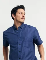Camisa azul con estampado de lunares blancos, de manga corta y corte clásico.