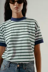 Camiseta de algodón orgánico con diseño a rayas horizontales verdes y blancas, cuello redondo y bordes de mangas en color azul marino. Presenta una letra R bordada en el pecho.