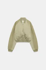 Chaqueta bomber de cuello redondo y manga larga con efecto lavado. Presenta bolsillos de vivo en el delantero, cierre frontal con cremallera y acabados en rib en cuello, puños y bajo.