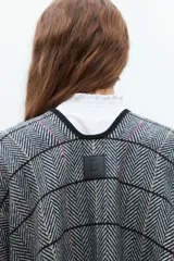 Capa gris con estampado escocés, cuello en V y lazo para atar en la cintura.
