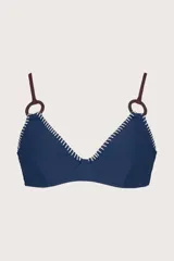 Top de bikini azul con costuras blancas en contraste, breteles finos marrones y aros de madera.