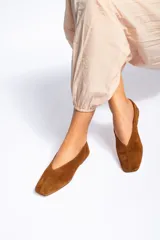 Chatas de cuero nobuck color marrón, con diseño de punta redondeada y suela plana.