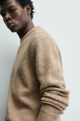 Sweater de punto color beige, de corte relajado, con cuello redondo y diseño texturizado en estructura waffle.