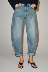 Jeans de tiro medio y corte balloon leg con efecto lavado, bolsillos clásicos y botamanga con vuelta.
