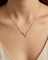 Collar de cadena fina con dije en forma de V, adornado con pequeñas circonias incrustadas.