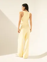 Pantalón negro de crepe con cintura cruzada, broche con brillo glitter, tiro alto, pinzado y pata ancha.