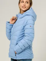 Campera puffer ligera de color celeste, con capucha y cordones ajustables, cuello alto, cierre frontal de cremallera y bolsillos laterales con cierre. Diseño acolchado con costuras horizontales y en V en el pecho.