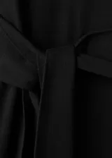 Vestido midi negro de manga larga, con escote redondo, lazo ajustable en la cintura y tajo lateral.