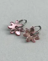 Aros de argolla metálica con dije colgante en forma de flor de acrílico color rosado.