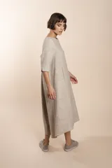 Vestido midi acampanado de lana fina sin teñir, con cuello bote, mangas tres cuartos con tajo y bolsillos laterales. Diseño forrado con vuelo y movimiento.