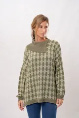 Buzo oversize de punto color verde oliva con cuello alto y diseño geométrico en dos tonos.