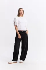 Remera blanca de algodón con mangas cortas que presentan volados dobles, aportando movimiento y un estilo femenino. Posee un corte recto y cuello redondo.