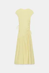 Vestido midi confeccionado en hilatura de algodón de color amarillo, con cuello redondo, manga corta y detalles de frunces laterales ajustables con cordones. Presenta bajo asimétrico con acabado en línea evasé.