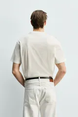 Camiseta de corte cropped fit confeccionada en algodón con acabado mercerizado que aporta suavidad y brillo. Presenta cuello redondo y mangas cortas.