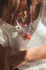 Pack de tres collares con dijes marinos, cuentas de colores y cadena de eslabones metálicos.