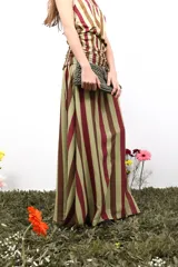 Falda larga de gasa con estampado tipográfico en color bordó sobre fondo beige. Presenta una silueta fluida y cierre lateral oculto.