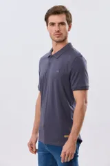 Remera polo de manga corta en color azul melange, con cuello camisero, cierre frontal de dos botones y pequeño bordado en el pecho.