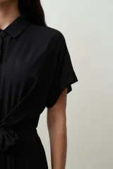 Mono largo negro de corte palazzo con camisa de mangas cortas con botones y lazo en la cintura.