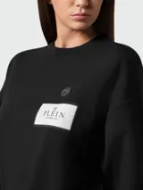 Sudadera negra de cuello redondo con logo de la marca Philipp Plein estampado en el frente.