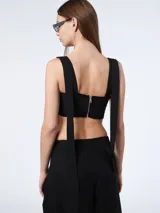 Top corto negro con breteles regulables y flecos de cuerina en el frente.