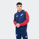 Canguro deportivo Umbro del Club Nacional de Football, color azul con capucha y cordones de ajuste, mangas rojas con detalles en celeste y blanco, bolsillos tipo canguro y el escudo del club junto con el logo de Umbro bordados en el frente.