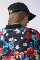 Campera bomber acolchada con cierre frontal, diseño estampado floral multicolor sobre base negra, cuello, puños y ruedo elásticos.