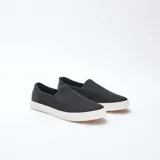 Zapatillas bajas slip-on negras de malla con suela blanca.