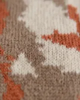 Buzo de tejido jacquard hecho a mano en mezcla de lana merino y seda, con diseño de formas orgánicas en tres colores. Presenta un calce relajado, cuello alto y terminaciones tejidas en rib.