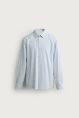 Camisa de corte regular fit confeccionada en tejido de algodón con diseño de rayas verticales finas. Presenta cuello italiano, manga larga con puños abotonados y cierre frontal mediante botonadura.
