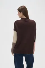 Sweater de punto con diseño de bloques de color en tonos marrón, beige y rosado, de corte holgado, cuello alto y mangas largas.