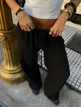 Pantalón negro de pierna ancha, corte relajado y fluido con textura tipo lino, cintura elastizada y cordón ajustable.