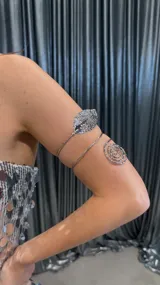 Brazalete plateado con diseño de hoja y espiral.