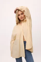 Camisa oversize a rayas verticales rosas y blancas, con cuello clásico, cierre frontal con botones y mangas largas.