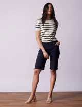 Bermuda blanca de gabardina elastizada marca Zac & Rachel. Tiene pretina ancha elastizada, bolsillos delanteros y traseros, y ruedo con dobladillo.