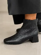 Bota corta de gamuza color marrón, con punta cuadrada y taco cuadrado de madera de altura media.