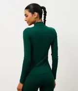 Campera deportiva Get Over de microfibra, con cuello alto, mangas largas, cierre frontal con cremallera y bolsillos laterales funcionales. Presenta un diseño ajustado con costuras verticales que realzan la silueta.
