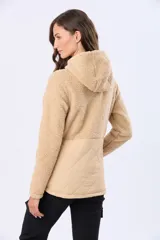 Campera beige con capucha y cordones ajustables, combinada en su parte superior con tejido de corderito y en su parte inferior con diseño capitoné. Cuenta con cierre frontal y broches a presión, además de bolsillos laterales.